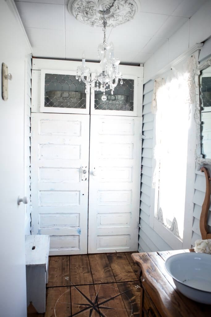 A mudroom that has a jacket closet made with salvaged doors.