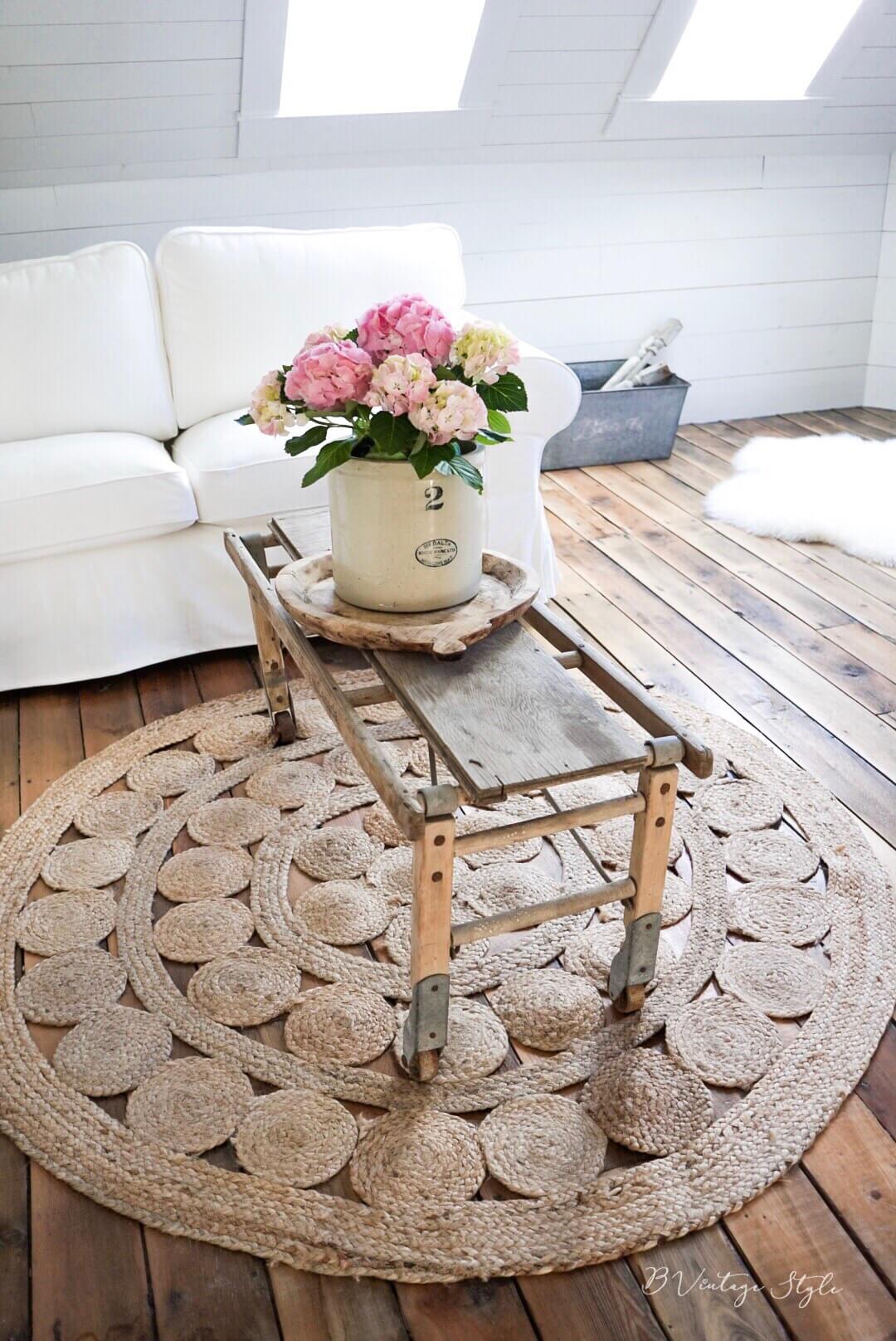 round rug with rustic coffee table salvaged coffee table crock full of flowers for farmhouse coffee table decor