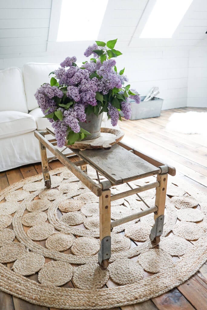 Lilacs in an antique bucket on a vintage coffee table