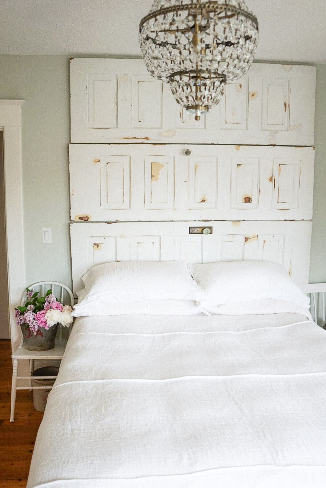 vintage details salvaged door headboard and farmhouse chandelier