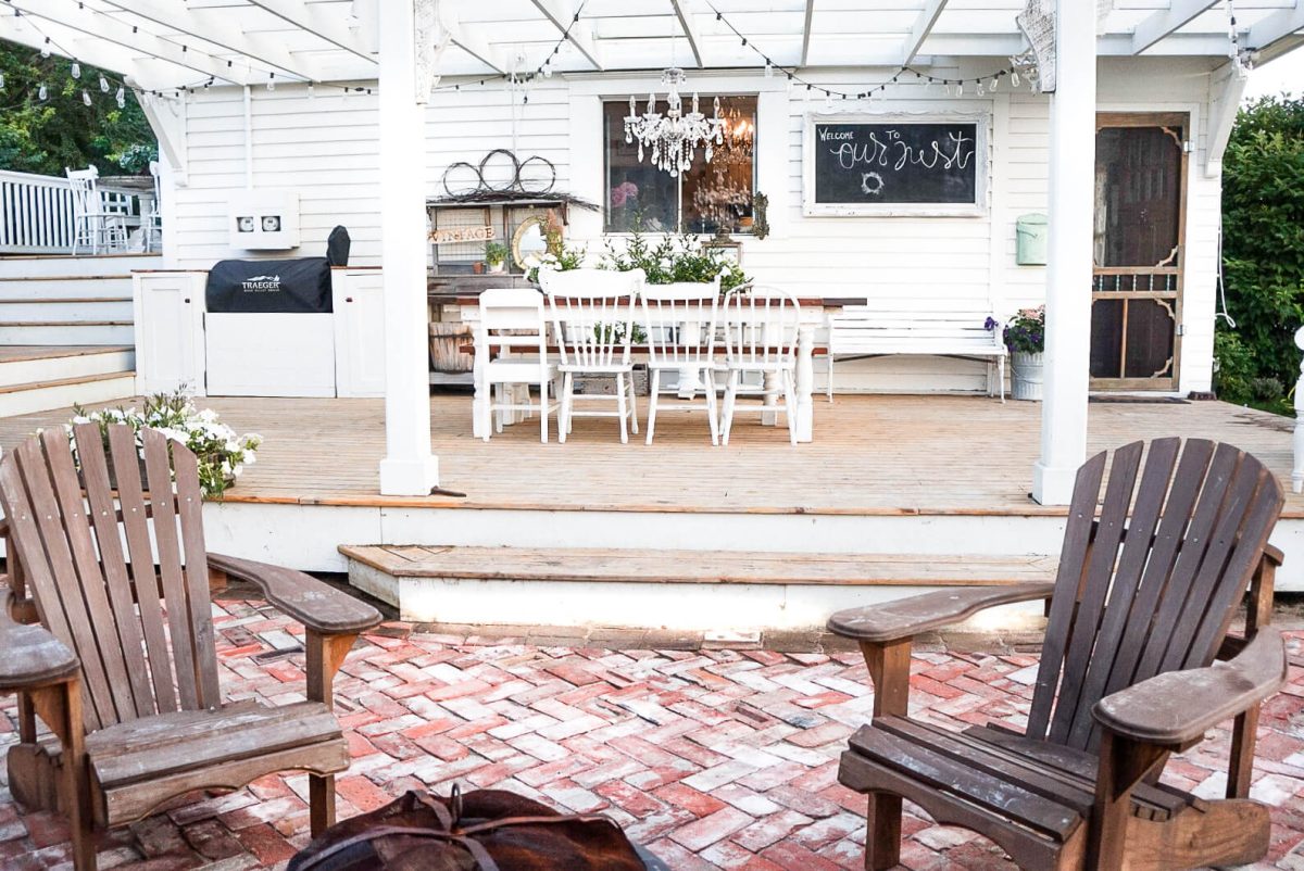 wood chairs next to the fire on the brick patio