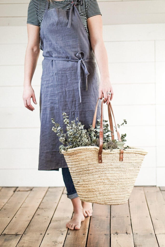 girl holding a market basket full of eucalyptus