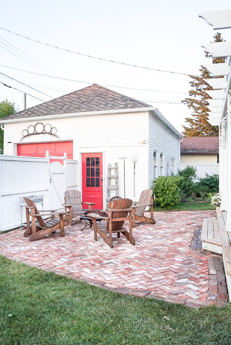 Adirondack chairs around a fire pit on a salvaged brick patio