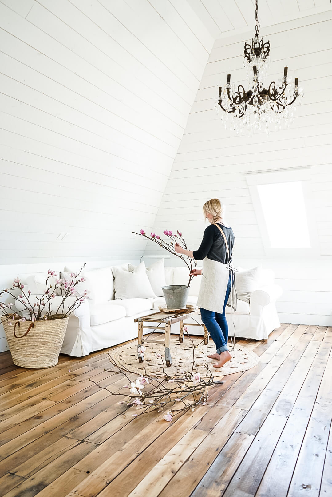 shiplap-attic-white-photo-shoot girl decorating the coffee table with magnolia