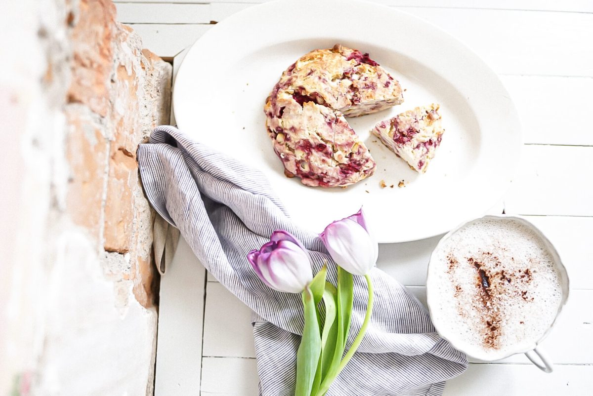 white chocolate raspberry scone with tulips and a brick wall