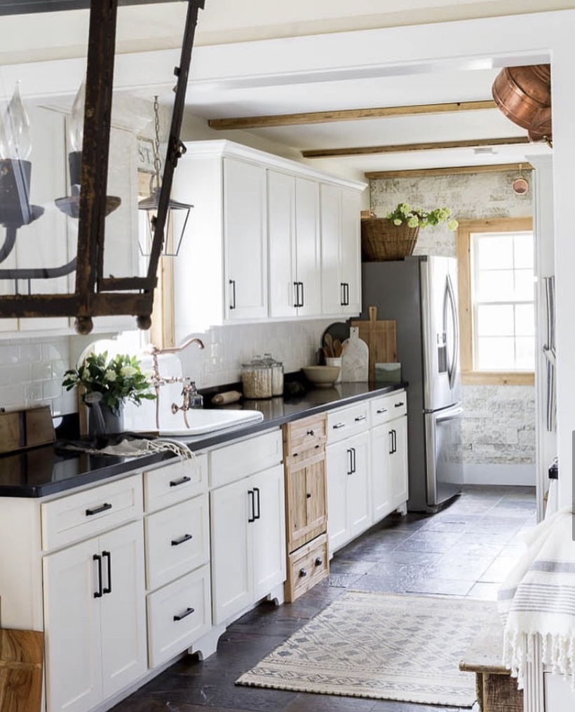 english cottage kitchen hidden dishwasher white cabinets dark counter top