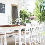 spool leg farmhouse dining table on the patio with mix match vintage chairs