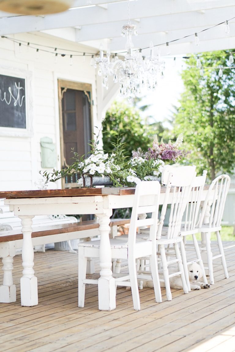 spool leg farmhouse dining table on the patio with mix match vintage chairs