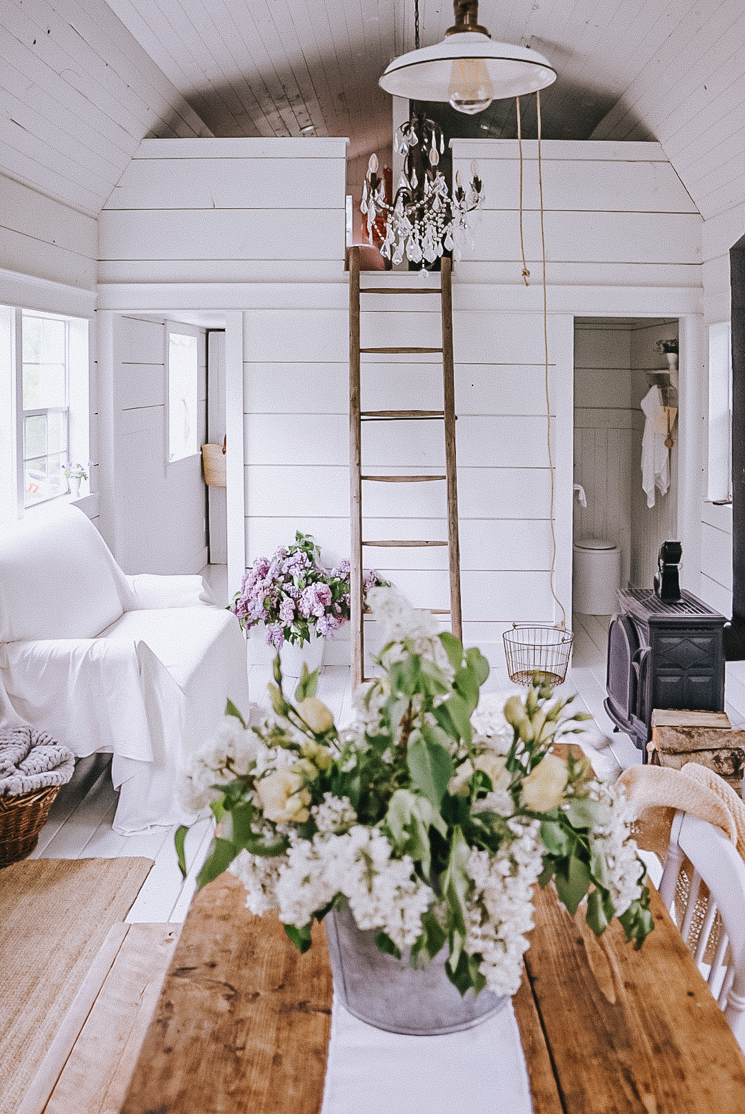 shed cabin living area and family room with a fireplace and chandelier