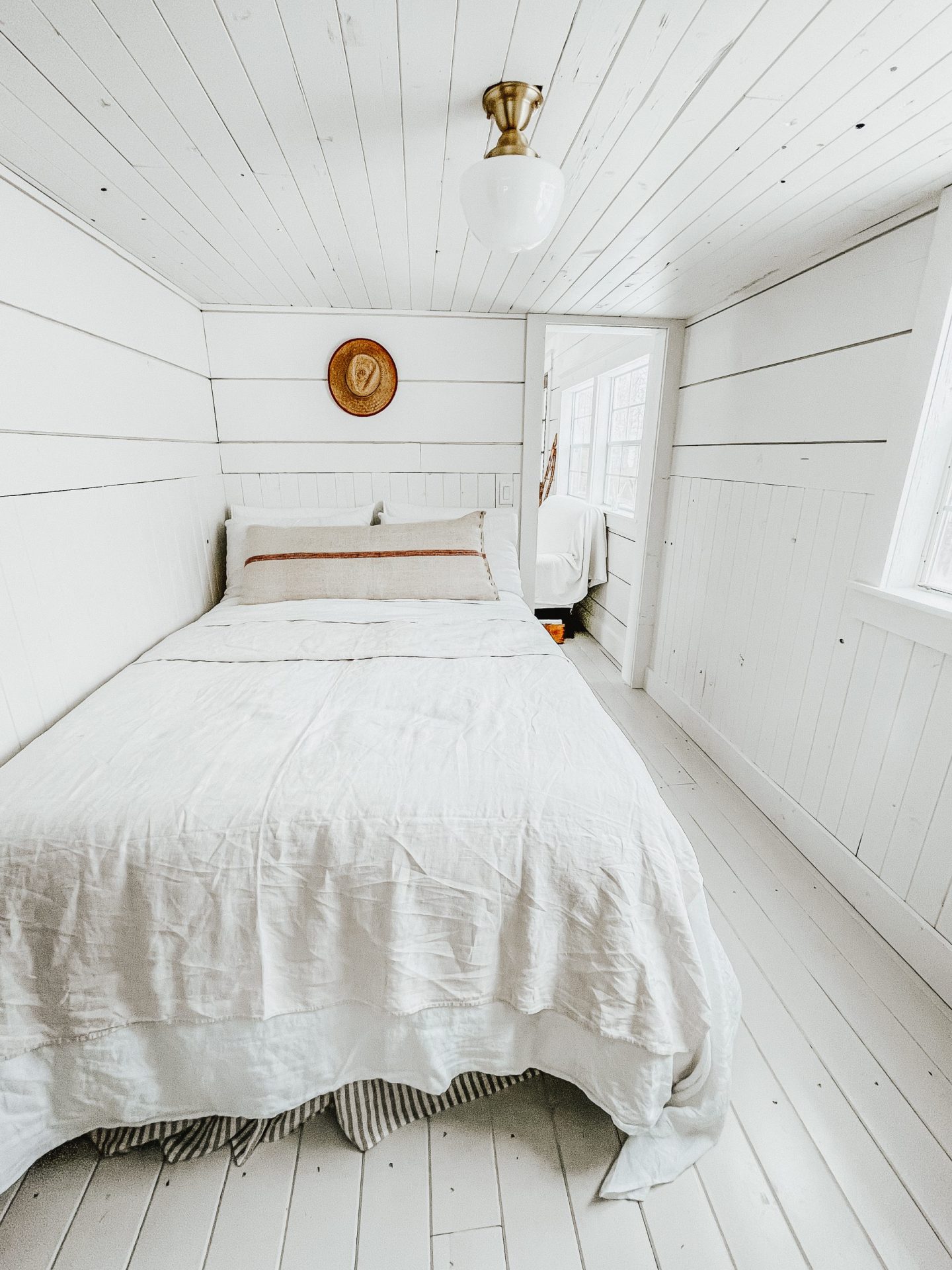 master bedroom in a cabin shed with linen bedding.