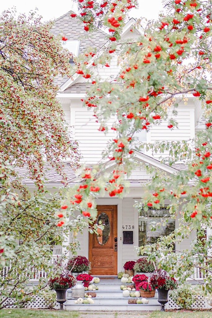 A beautiful white Victorian home decorated for fall.