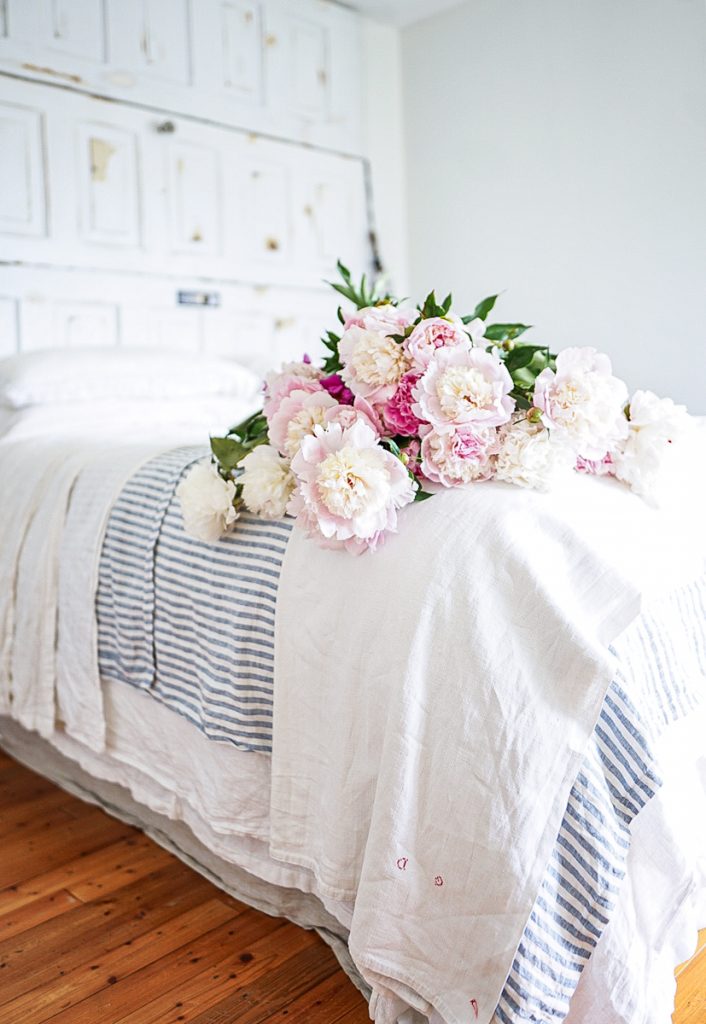 blue and white linen sheets with peonies on the bed