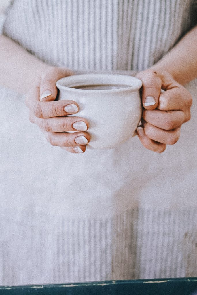 girl holding a large coffee mug