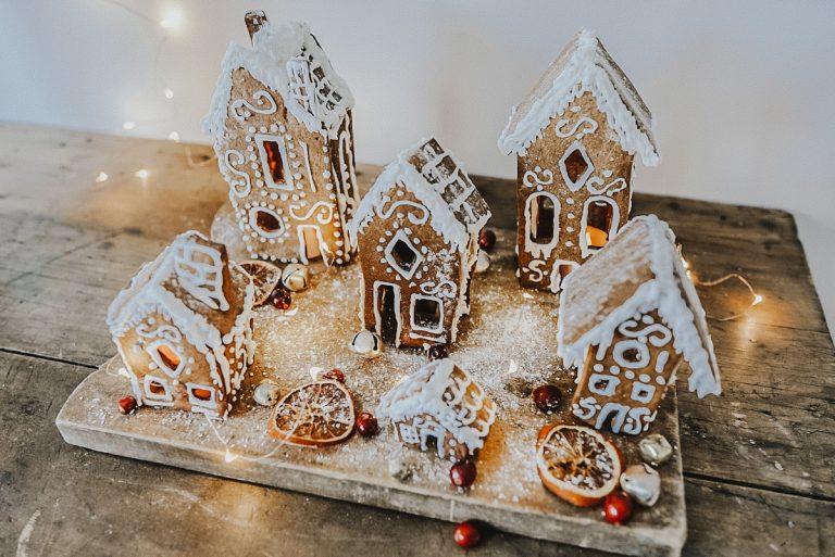 gingerbread village on a vintage board with gingerbread houses and twinkle lights