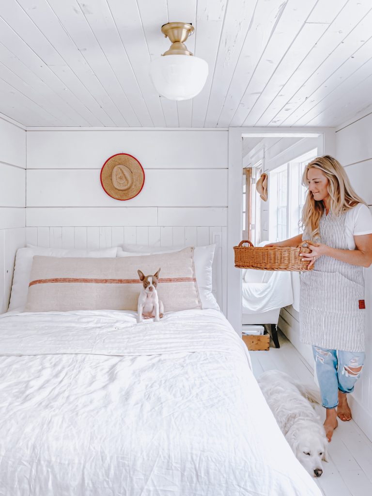 girl walking into a bedroom with white bedding and simplifying your home