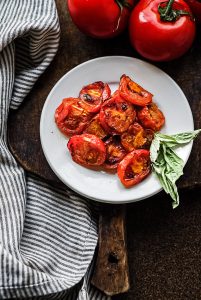 fire roasted tomatoes on a plate with basil