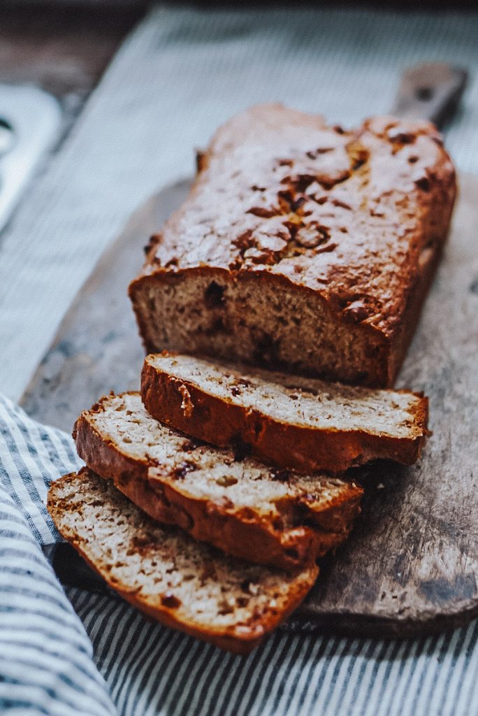 no butter banana bread cut on an antique cutting board
