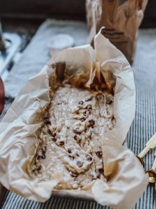 banana bread batter poured into a parchment paper bread pan