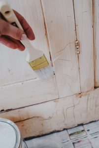 brushing paint on a cabinet