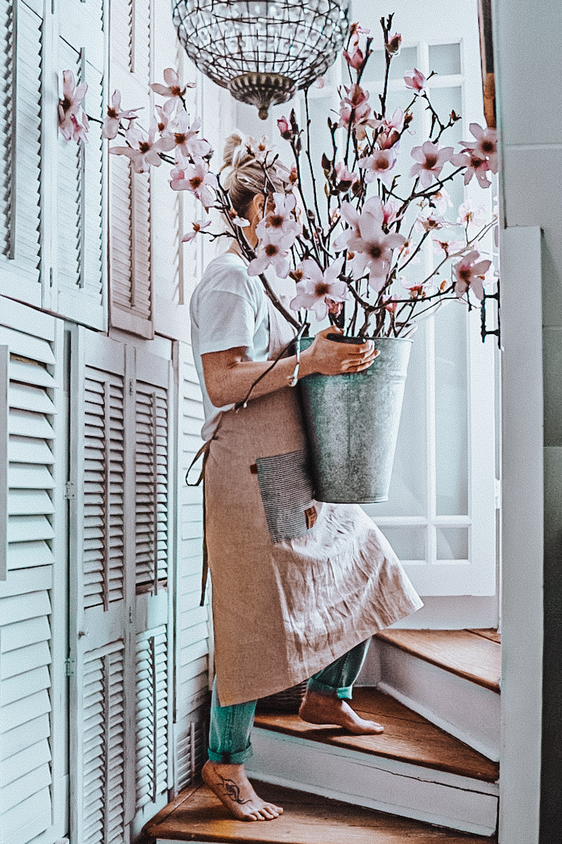 Deborah, B Vintage Style, walking up a staircase with blooming magnolia branches