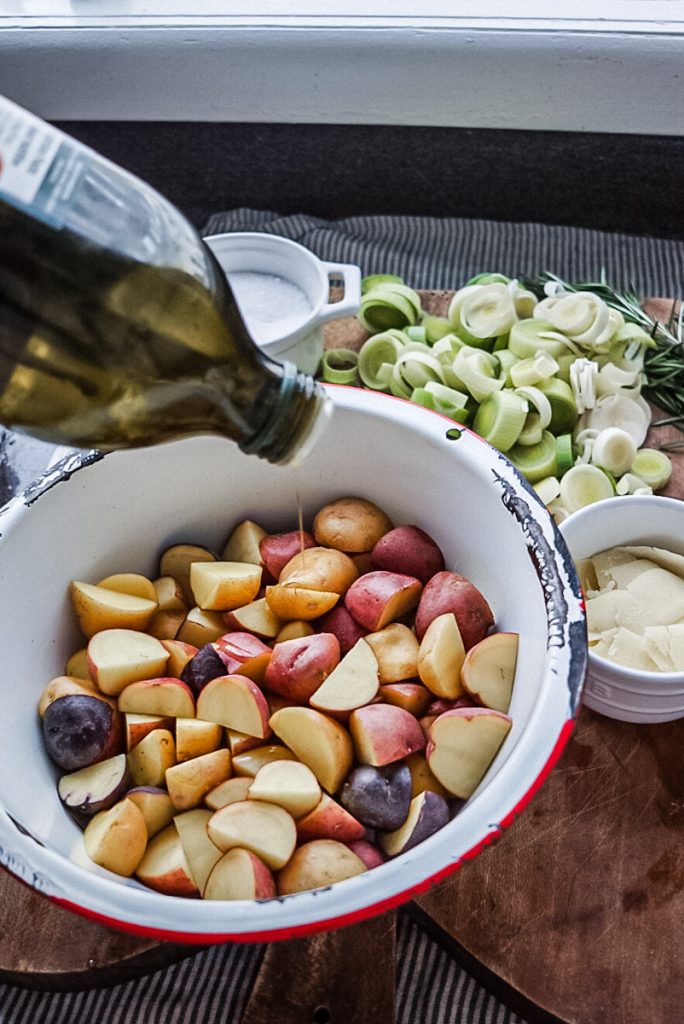 adding olive oil to potatoes for a chicken and leek recipe