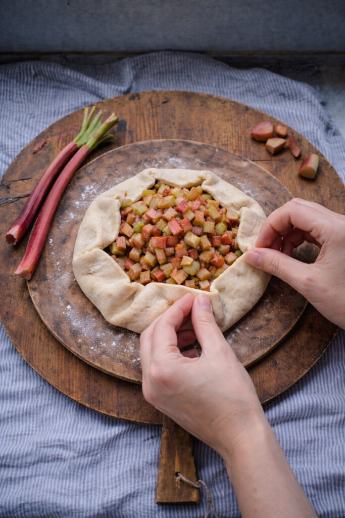 Folding up the crust of a rhubarb galette to go into the oven. 