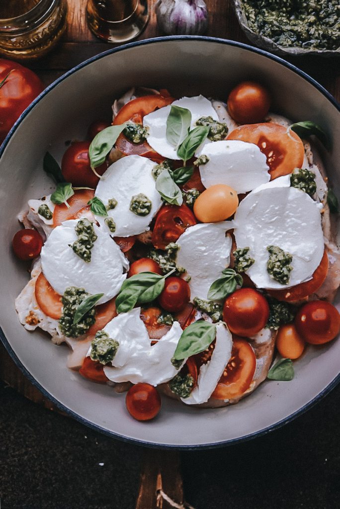 adding fresh bail to the top of Caprese chicken