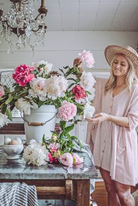 Deborah at B Vintage Style in her kitchen arranging peonies of all different colors and variations