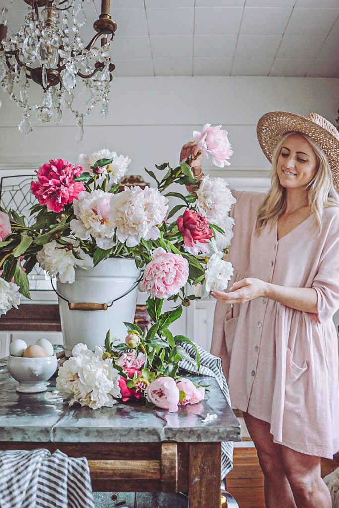 Deborah at B Vintage Style in her kitchen arranging peonies of all different colors and variations