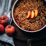 Delicious peach crumble with oats in a vintage ironstone dish.