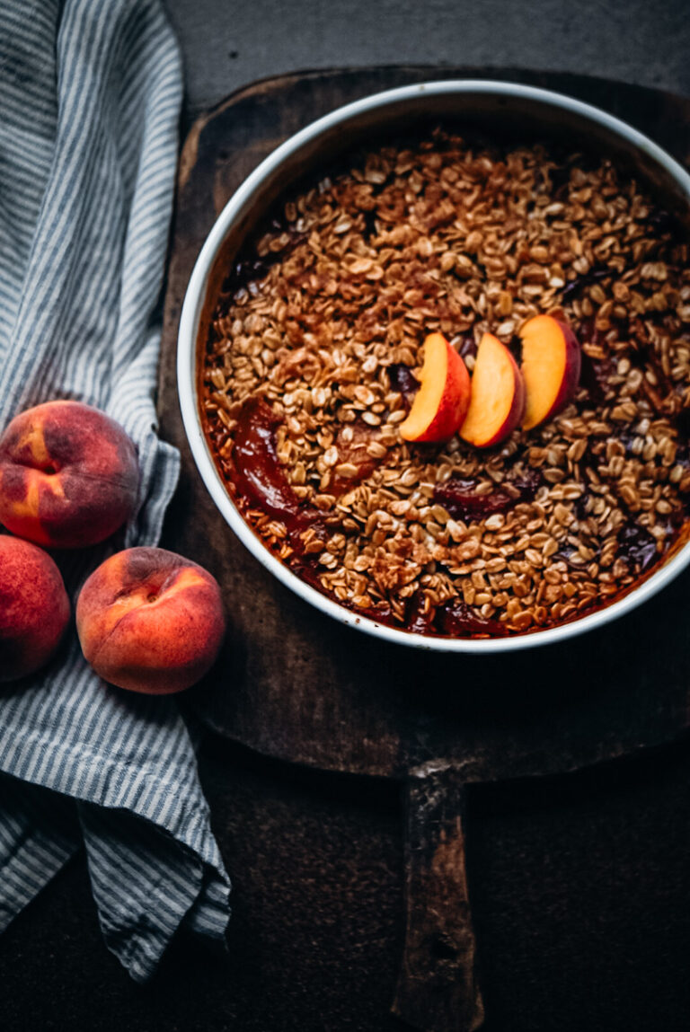 Delicious peach crumble with oats in a vintage ironstone dish.
