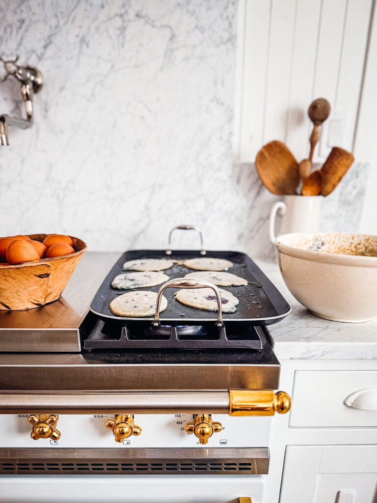 The hexclad griddle being used to make pancakes on Deborah's French lacanche stove. 
