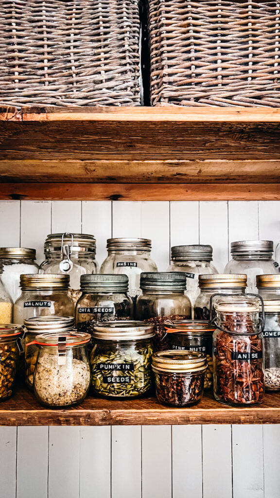 Jars with embossed labels on them in a pantry.
