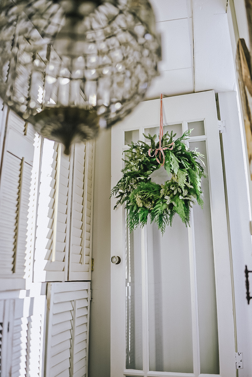 A beautiful DIY winter wreath made of fresh evergreen hanging on a door.