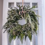 Fresh evergreen wreath for winter, hanging from a door.