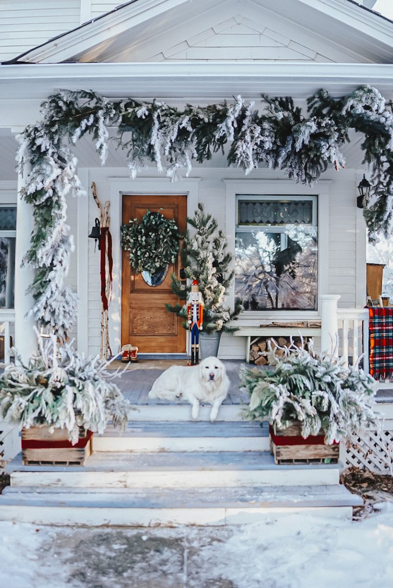 A beautiful view of the front porch of the Victorian house decorated for Better Homes & Gardens Farmhouse Christmas Magazine.