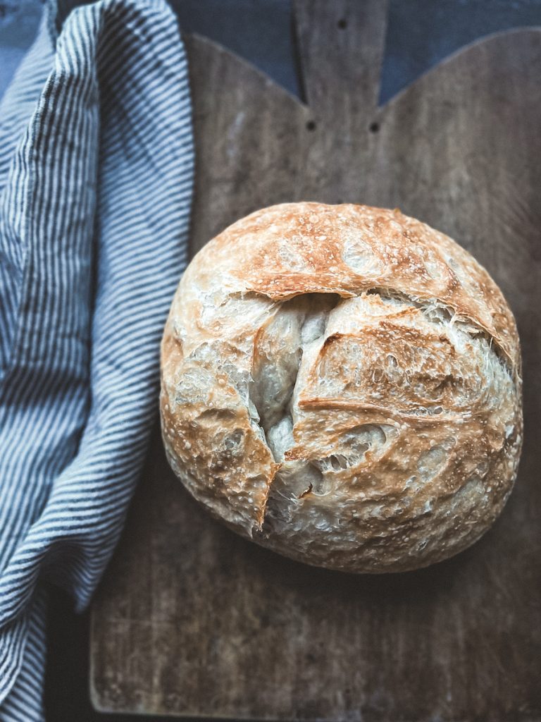 Beautiful loaf of homemade Artisan bread on a cutting board.