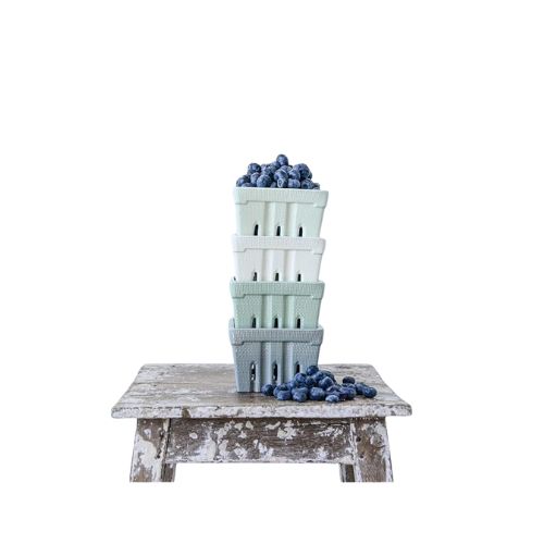 Berry strainers in different spring colors holding blueberries.