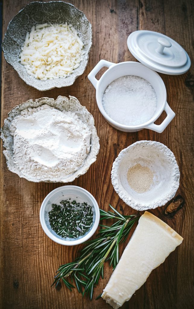 Flour, kosher salt, yeast, grated parmesan cheese and fresh rosemary all ingredients to make rosemary parmesan bread.