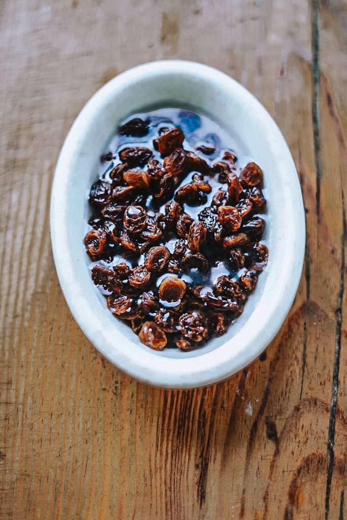 Rehydrating raisins to make raisin bread.