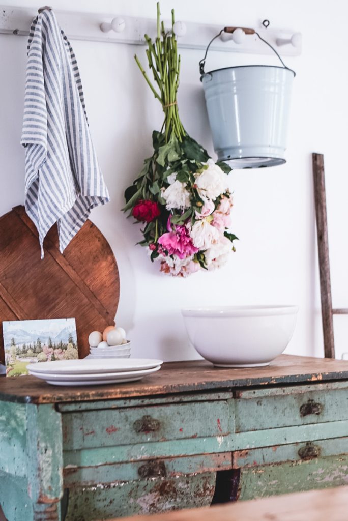 Beautiful bundle of peonies that have been hung above a desk to be dried.
