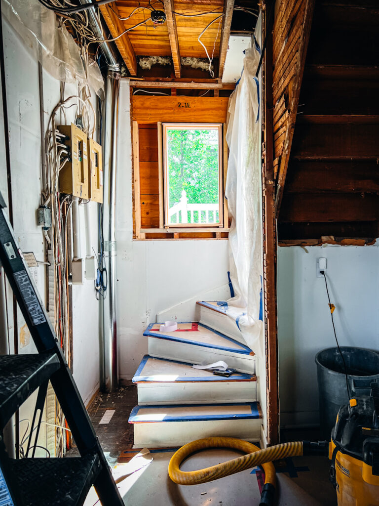 A new window that has been added to a house during a renovation beside a staircase.