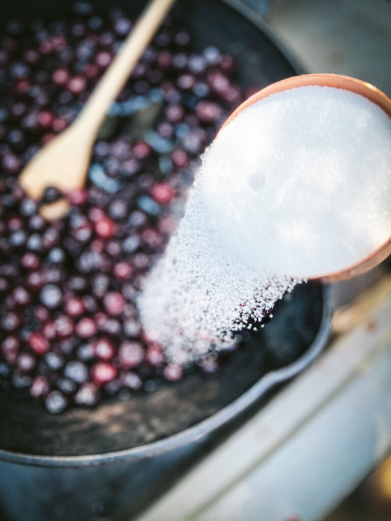 Adding sugar to Saskatoon berries.