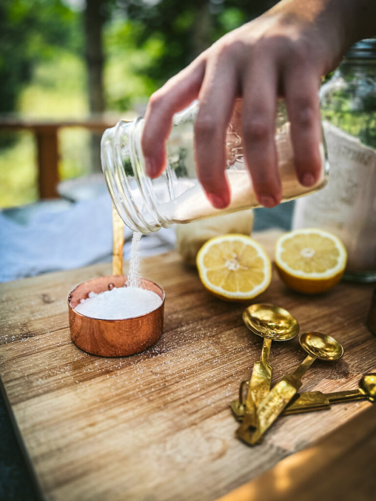 Pouring sugar into a measuring cup.