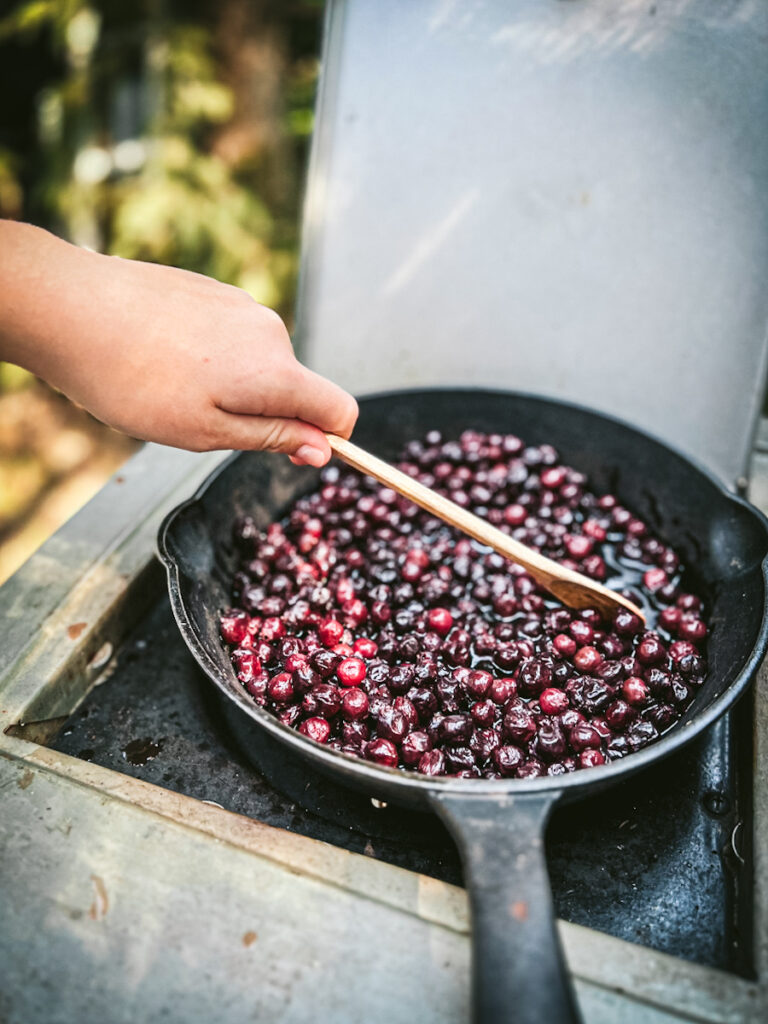 Simmering Saskatoon berries in a cast iron pan to make a pie.