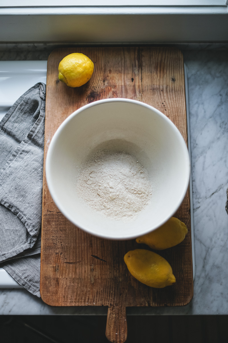 Flour in a large mixing bowl to make a lemon poppy seed loaf.