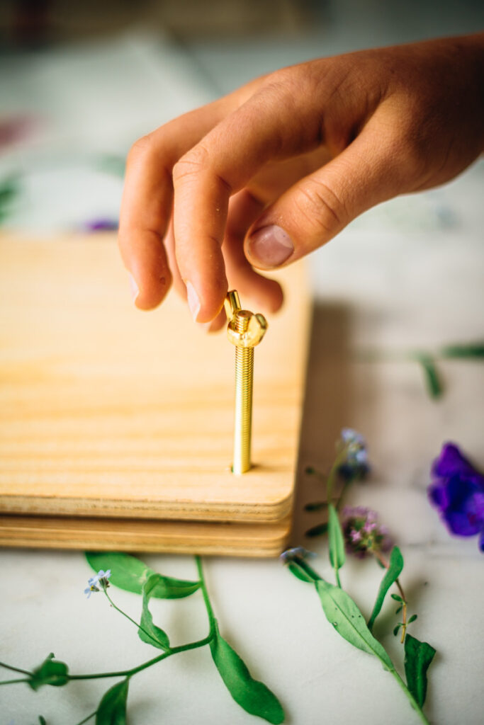 Screwing the bolts onto the flower press.