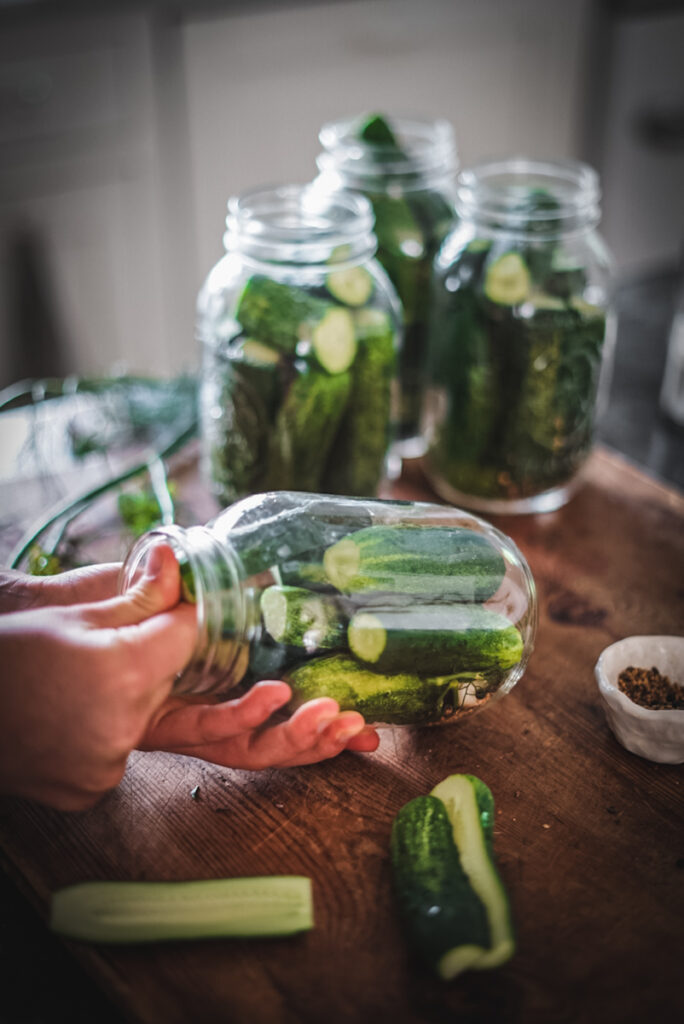 Stuffing pickles into a jar to make dill pickles.