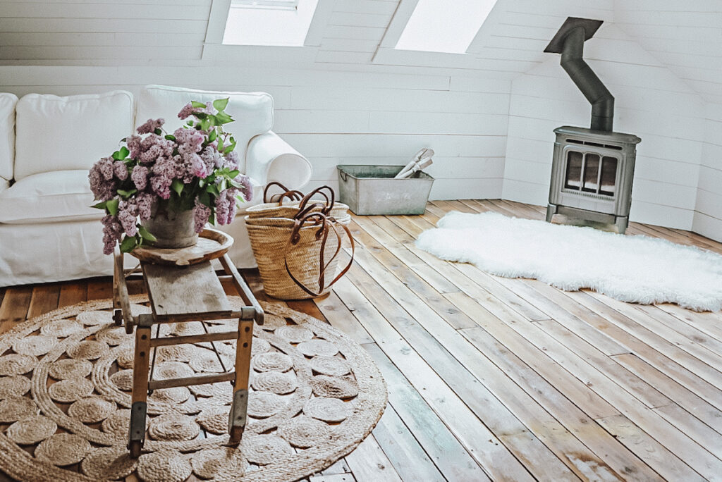 Sheepskin rug in front of a freestanding fireplace beside a white sofa.