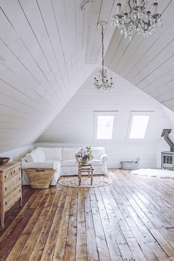 Fully finished attic space with white clapboard walls, a natural gas fireplace, and four original hardwood floors. 